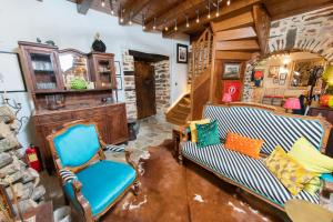 sala de estar con 2 sillas y pared de piedra en Αρχοντικό 1716, en Agios Lavredios