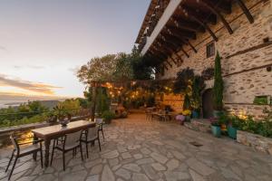 Un patio con mesas y sillas y un edificio. en Αρχοντικό 1716, en Agios Lavredios