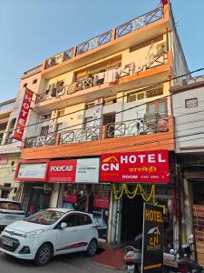 une voiture blanche garée devant un hôtel dans l'établissement CN Comforts Hotel & Dormitory, à Lucknow