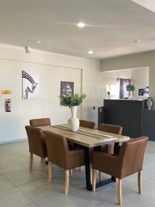 a dining room table and chairs with a vase on it at 63 Lodging Villa in Rustenburg