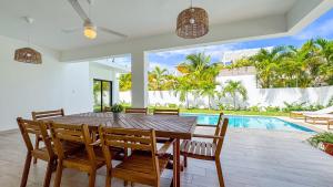 a dining room with a table and chairs and a pool at Sosua Ocean Village - Villas Marinas 27B in Sosúa