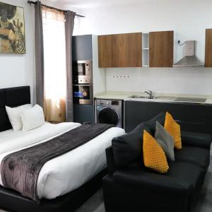 a bedroom with a bed and a couch and a kitchen at Krater apartments in Accra