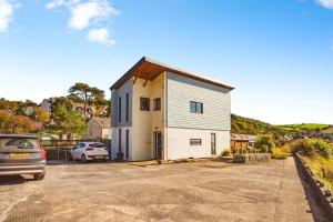 a house with a car parked in a parking lot at Beachside in Ferryside