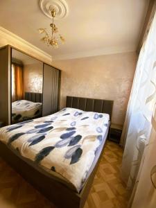 a bedroom with a bed and a large mirror at Sunrise Apartment Gai Avenue One, Yerevan in Yerevan
