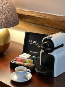 a coffee maker and a cup of coffee on a table at Zámecký hotel & Wellness in Poděbrady