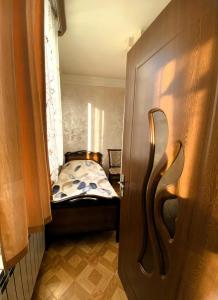 a small room with a bed and a door at Sunrise Apartment Gai Avenue One, Yerevan in Yerevan