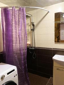 a purple shower curtain in a bathroom with a sink at Sunrise Apartment Gai Avenue One, Yerevan in Yerevan