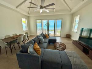 un salon avec un canapé bleu et une table dans l'établissement Slipstream, à Long Island 11 autres photos