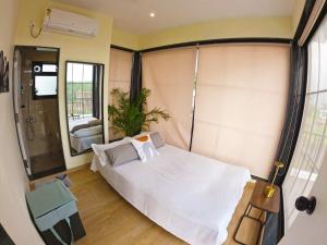 Stay Leisurely Casa Astre 3BHK, Karjat في كارجات: غرفة نوم بسرير أبيض ومرآة +31 صورة