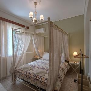 a bedroom with a canopy bed and a window at A home away from your home in Chios