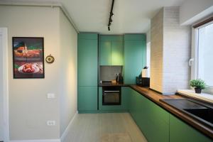 a kitchen with green cabinets and a counter at Nest & Rest Apartment Fast Wi-Fi Free Parking in Braşov
