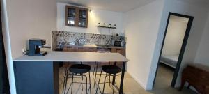 een keuken met een aanrecht en 3 barkrukken bij La cigala in Le Pradet