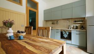 a kitchen with a wooden table in a kitchen at Cave Holiday Apartment in Cave del Predil