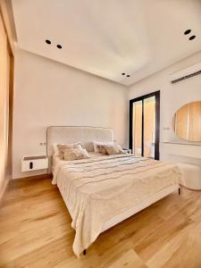 a bedroom with a large bed with a large window at Maison Miralin Beach in Hammam Sousse