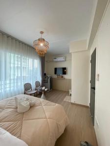 a bedroom with a large bed with a chandelier at Mari Home in Bangsaen