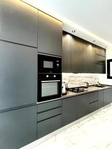 a kitchen with black appliances and stainless steel cabinets at Maison Miralin Beach in Hammam Sousse +15 photos