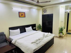 a bedroom with a large bed with white sheets at Hotel jain palace in Chhatarpur