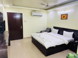 a bedroom with a bed and a chair in it at Hotel jain palace in Chhatarpur