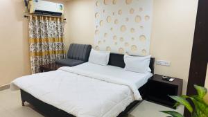 a bedroom with a bed and a chair at Hotel jain palace in Chhatarpur