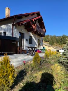 a house with a picnic table in front of it at Cabana Stânceni in Drăgoiasa