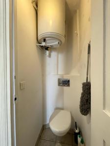 ein kleines Bad mit einem WC und einer Lampe in der Unterkunft Elegant 2-bedroom apartment near Paris & Château de Vincennes in Nogent-sur-Marne