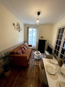 ein Wohnzimmer mit Sofa und Tisch in der Unterkunft Elegant 2-bedroom apartment near Paris & Château de Vincennes in Nogent-sur-Marne