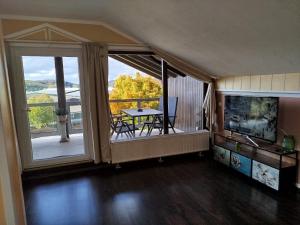a room with a table and a balcony with a view at Haus am Aartalsee in Bischoffen