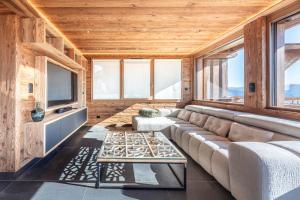 a living room with a couch and a table at Chalet de Scott, luxe avec spa et sauna in Gérardmer