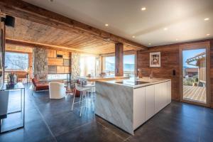 a kitchen with a counter and a living room at Chalet de Scott, luxe avec spa et sauna in Gérardmer