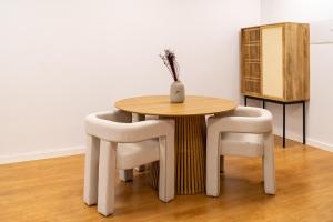 een tafel en twee stoelen met een vaas erop bij Business office - Studio with garage in Linda-a-Velha