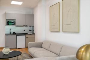 een woonkamer met een bank en een keuken bij Business office - Studio with garage in Linda-a-Velha