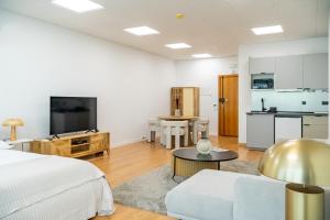 een woonkamer met een bed en een keuken bij Business office - Studio with garage in Linda-a-Velha