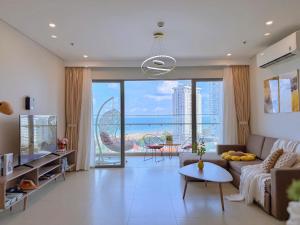 a living room with a couch and a large window at The Song Boutique Apartment in Vung Tau