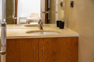 een badkamer met een wastafel en een spiegel bij Business office - Studio with garage in Linda-a-Velha