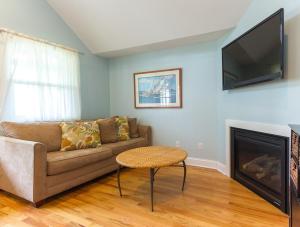 a living room with a couch and a flat screen tv at Beautiful & Romantic 1BR Cottage w/Beach Locker in Ocean Grove