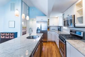 a kitchen with white cabinets and a counter top at Beautiful & Romantic 1BR Cottage w/Beach Locker in Ocean Grove