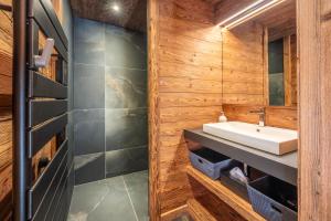 a bathroom with a sink and wooden walls at Chalet de Scott, luxe avec spa et sauna in Gérardmer +31 photos
