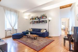 a living room with a blue couch and a table at Suite Manzoni by Houset in Monza