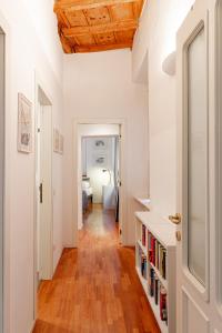 a hallway with white walls and a wooden ceiling at Suite Manzoni by Houset in Monza
