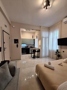 イオアニナにあるLorien City Center Apartmentsのベッドとソファとテーブルのある寝室