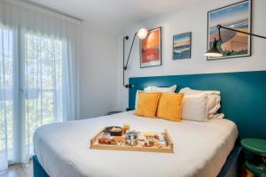 a tray of food on a bed in a room at Urban Style Victoria Boutique Hotel in Arcachon