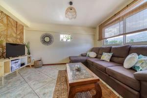 a living room with a couch and a tv at Kaz Latania in Étang-Salé
