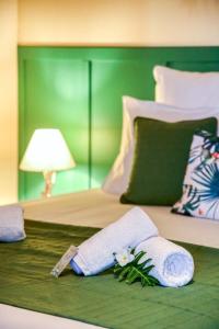 a bed with two towels and a flower on it at Kaz Latania in Étang-Salé