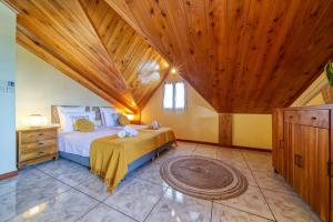 a bedroom with a bed and a wooden ceiling at Kaz Latania in Étang-Salé