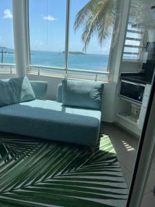 a couch in a room with a view of the ocean at Guadeloupe Ilet Gosier best view in Le Gosier