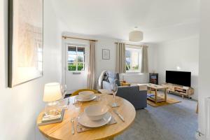 una sala de estar con una mesa y un sofá en Coorie Nook, en Windermere