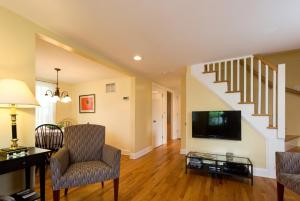 a living room with a tv and a staircase at 3BR Beautiful Remodeled Victorian w/ Beach Locker in Ocean Grove