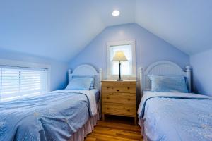 a blue bedroom with two beds and a lamp on a dresser at 3BR Beautiful Remodeled Victorian w/ Beach Locker in Ocean Grove +46 photos