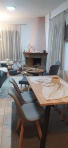 a living room with a table and chairs and a fireplace at Αρσινόη apartments 4 in Arachova