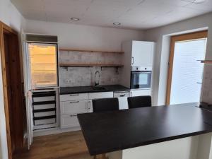 a kitchen with white cabinets and a black counter top at FeWo Pfaffenhofen-Ortsteil Blick ins Grüne in Pfaffenhofen an der Ilm